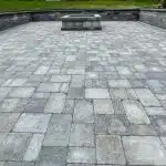 a stone patio with a fire pit