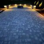 a stone driveway with lights