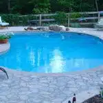 a swimming pool with a fence and trees