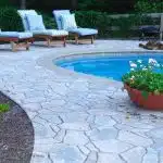 a pool with lounge chairs and a planter