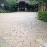 a brick driveway with trees in the background