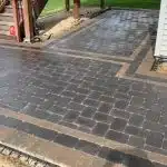 a brick driveway with a white building in the background