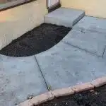 a concrete walkway with dirt around it