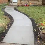 a concrete walkway in front of a house