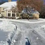 a house with a large driveway in the snow