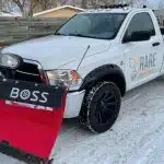 a white truck with a red plow